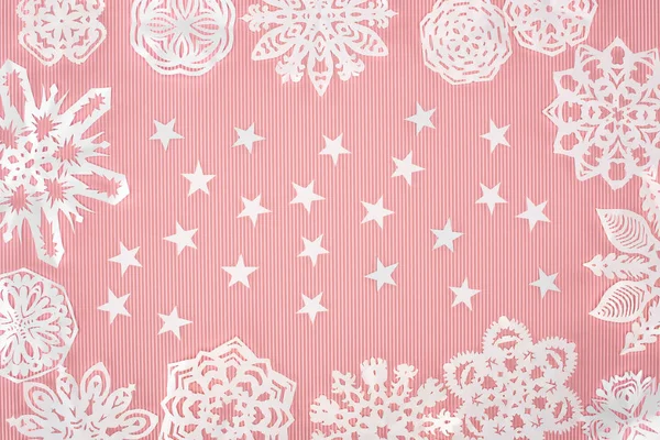 Fond de Noël avec des flocons de neige en papier et des étoiles sur rose — Photo de stock