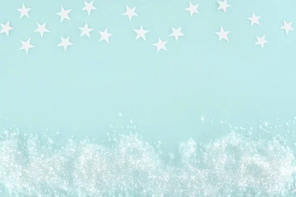 Fond de Noël avec neige décorative et étoiles, isolé sur bleu clair — Photo de stock
