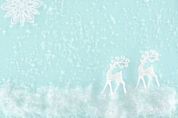 Fondo de Navidad con nieve decorativa, copo de nieve y ciervos de papel, aislado en azul claro - foto de stock