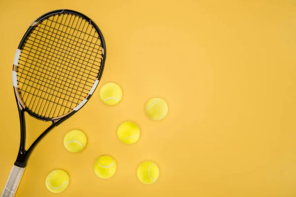 Tennisschläger mit Bällen isoliert auf gelb — Stockfoto