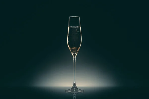 One transparent glass with champagne on black — Stock Photo