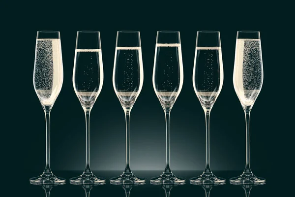 Seis copas transparentes con champán en negro - foto de stock