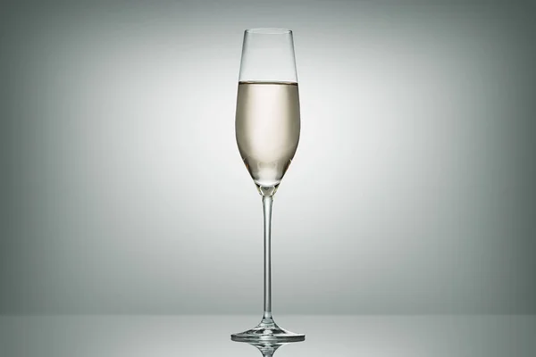 One glass with calm champagne on white — Stock Photo