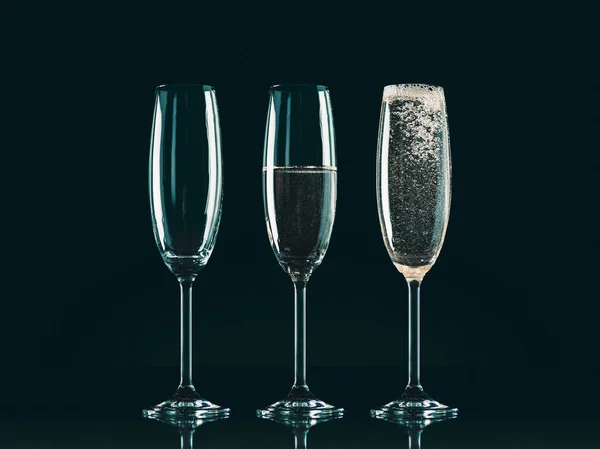 Три бокала с разным уровнем шампанского на черном — стоковое фото