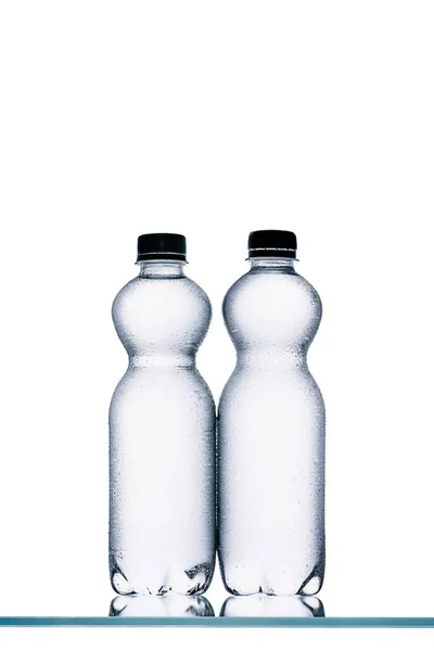 Bottiglie di plastica umida di acqua isolata su bianco — Foto stock