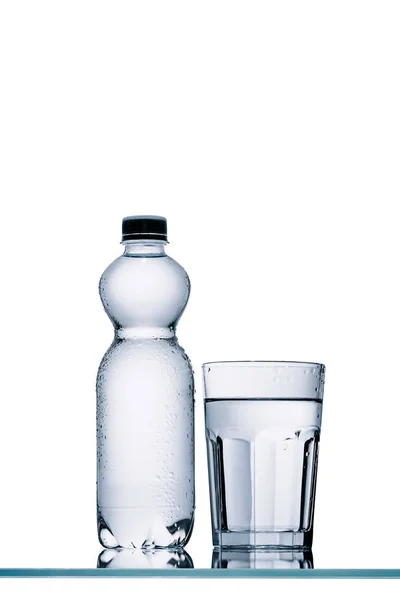 Bottiglia di plastica piena di acqua e vetro isolato su bianco — Foto stock