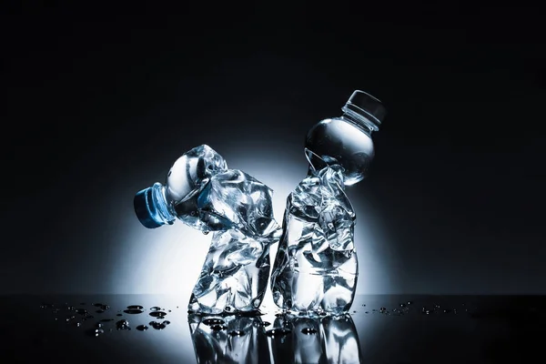 Збиті пластикові пляшки води на темряві — стокове фото