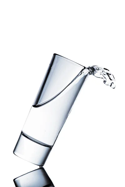 Water spilling from glass isolated on white — Stock Photo