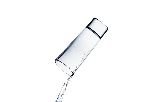 Fuoriuscita di acqua da vetro isolato su bianco — Foto stock