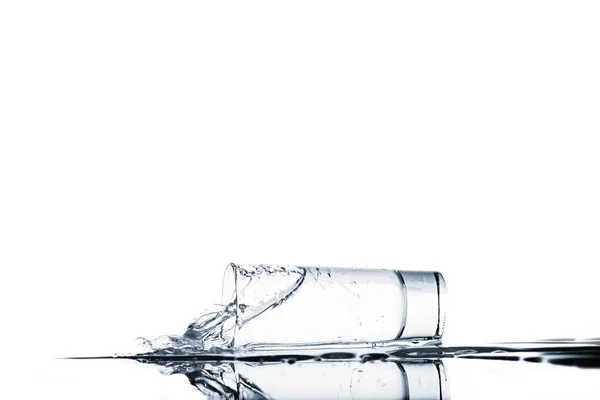 Разлив воды из стекла, изолированного на белом — стоковое фото
