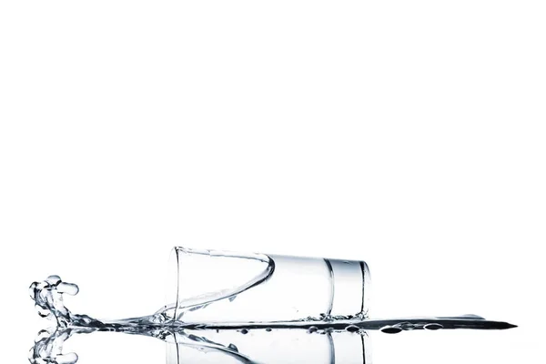 Vue du déversement d'eau du verre isolé sur blanc — Photo de stock