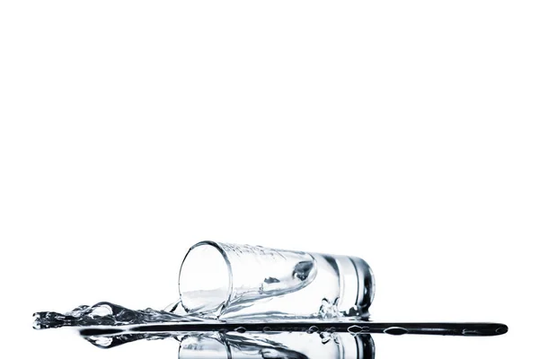 Sauberes Wasser verschüttet aus Glas isoliert auf weiß — Stockfoto