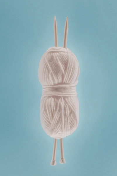 Vue de dessus de boule de tricot blanche avec aiguilles à tricoter, isolée sur bleu — Photo de stock