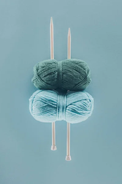 Vista superior de fios de tricô azul com agulhas de tricô, isolado em azul — Fotografia de Stock