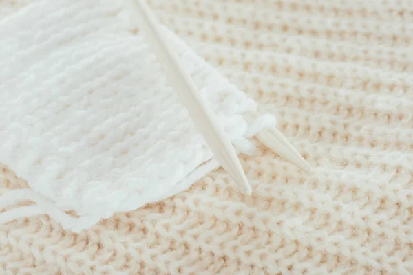 Gros plan des aiguilles à tricoter avec du fil de laine blanche — Photo de stock