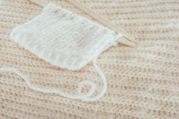 Primer plano de agujas de tejer con hilo de lana blanco - foto de stock