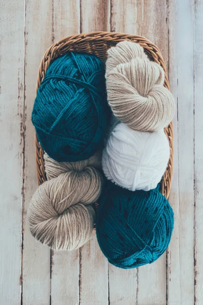 Top view of knitting yarn in wicker basket on wooden background — Stock Photo