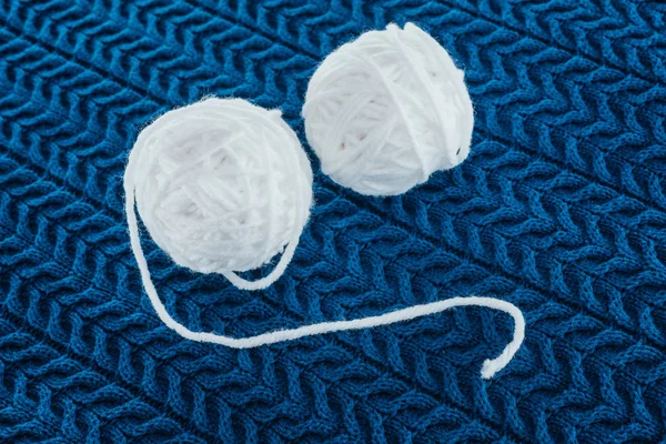 Deux boules de fils à tricoter sur tricot bleu — Photo de stock