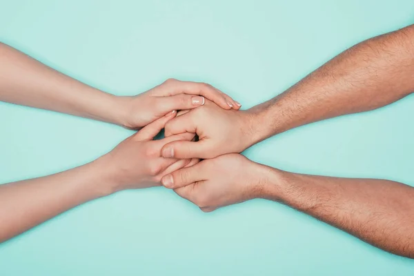 Cropped shot of couple holding hands isolated on turquoise — Stock Photo