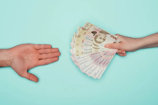 Cropped shot of people passing cash isolated on turquoise — Stock Photo
