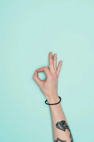 Cropped shot of woman showing okay sign isolated on turquoise — Stock Photo