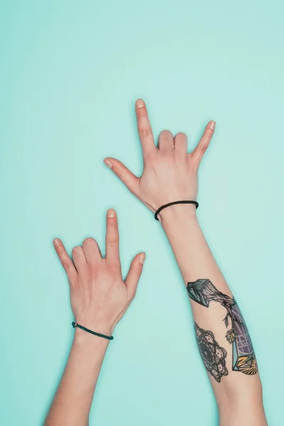 Cropped shot of woman showing horns signs isolated on turquoise — Stock Photo