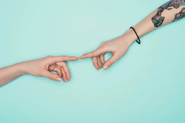 Plan recadré de femmes touchant des doigts isolés sur turquoise — Photo de stock
