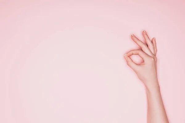 Обрезанный снимок женщины показывая хорошо знак изолирован на розовый — стоковое фото