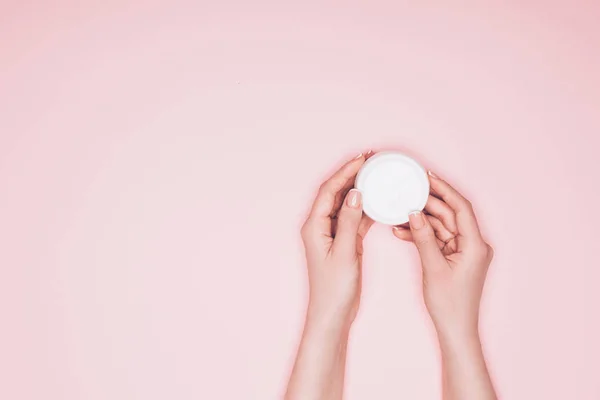 Cropped shot of woman holding opened can of moisturizing cream isolated on pink — Stock Photo