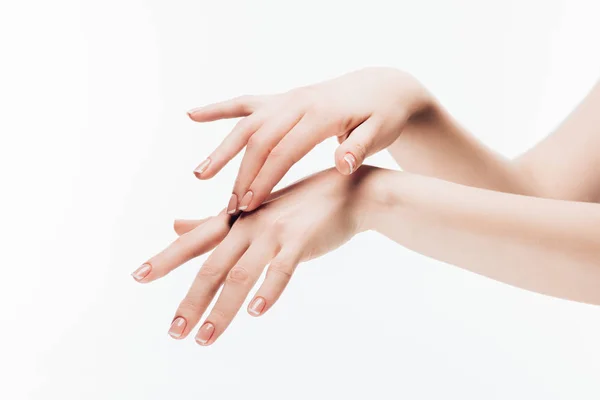 Colpo ritagliato di donna che applica crema idratante su mani isolate su bianco — Foto stock
