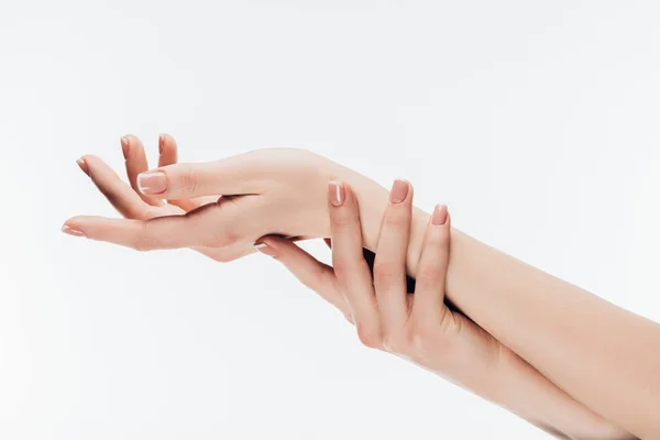 Plan recadré de la femme avec des ongles élégants appliquer crème hydratante sur les mains isolées sur blanc — Photo de stock