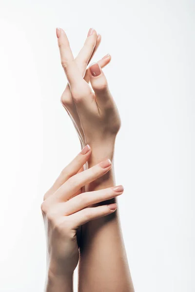 Recortado tiro de manos femeninas con hermosas uñas aisladas en blanco - foto de stock