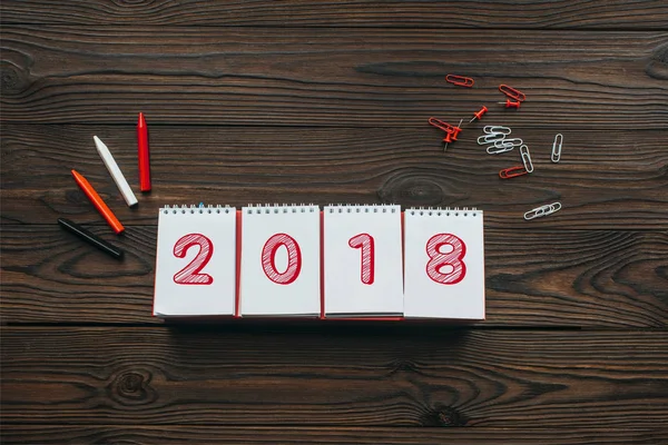 Верхний вид календаря 2018 года, карандаши и канцелярские принадлежности на деревянном столе — стоковое фото