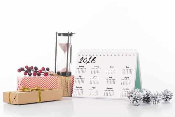 Vista de cerca de la disposición del calendario, reloj de arena y regalos envueltos aislados en blanco - foto de stock