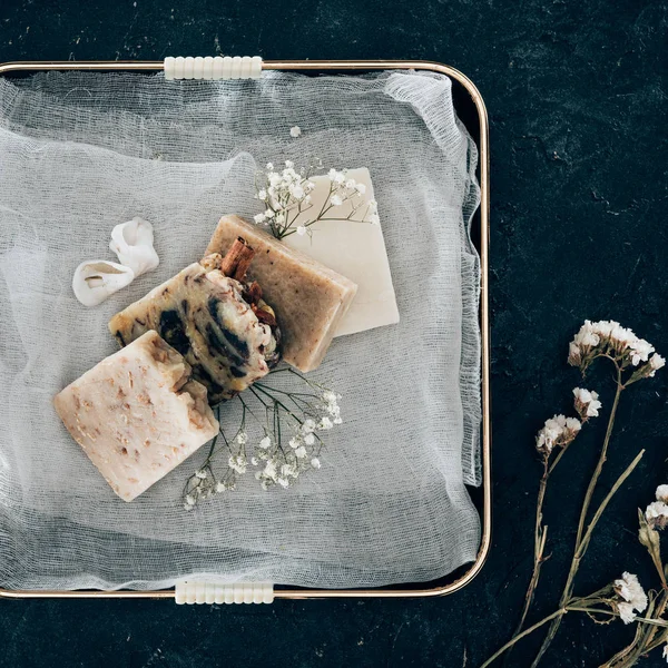 Top view of natural homemade soap and dried flowers on gauze in tray — Stock Photo