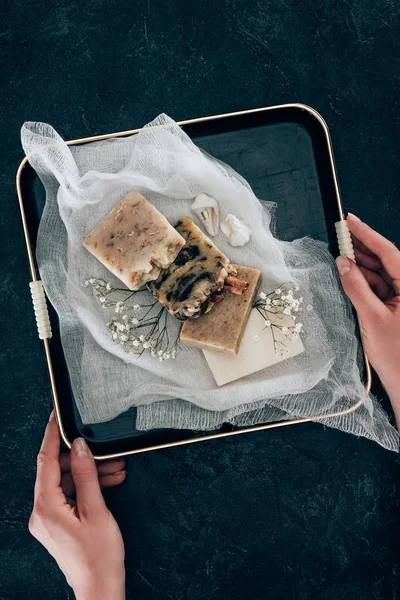 Abgeschnittene Ansicht von Frauenhänden mit natürlicher hausgemachter Seife auf Gaze in Tablett — Stockfoto