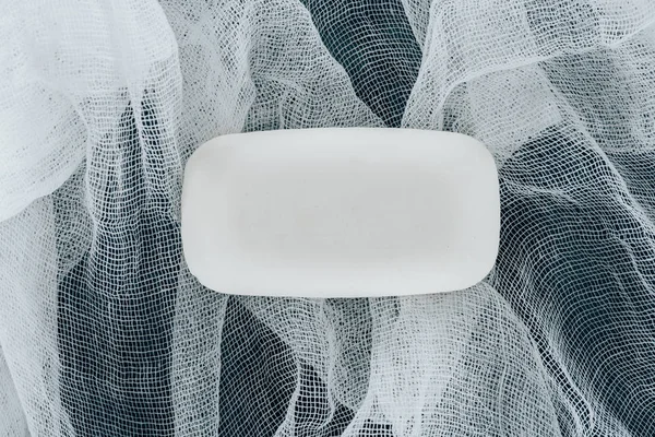 Top view of white soap on gauze on black table — Stock Photo