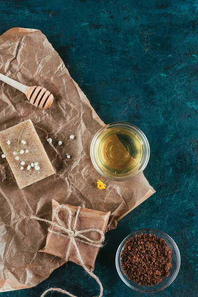Вид зверху на природне мило, олію та кавовий скраб для спа-центру на збитому папері на поверхні зеленого мармуру — Stock Photo
