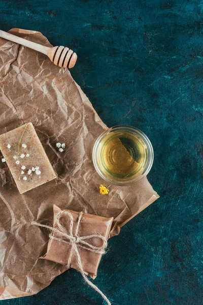 Vista dall'alto di sapone naturale e olio per spa su carta sgualcita su superficie di marmo verde — Foto stock