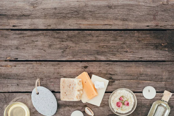 Vue de dessus du savon naturel, huile, gommage au sel, pierre ponce et traitement spa sur table en bois — Photo de stock