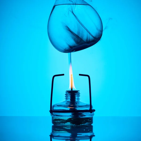 Warming up liquid for chemical test on blue — Stock Photo