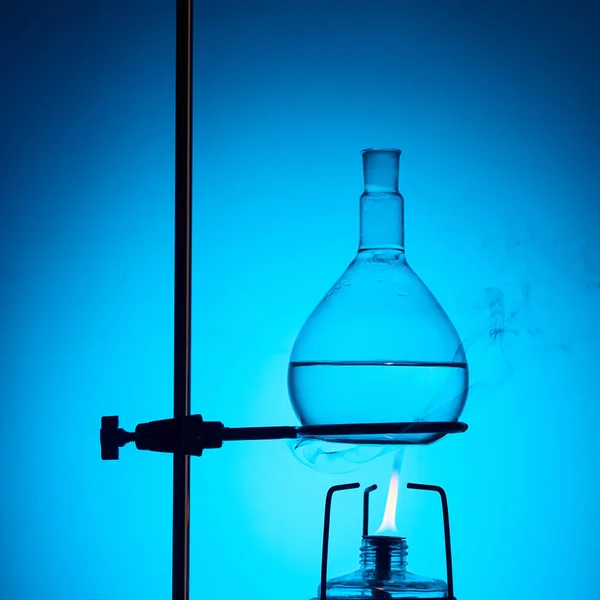 Warming up liquid for chemical test isolated on blue — Stock Photo