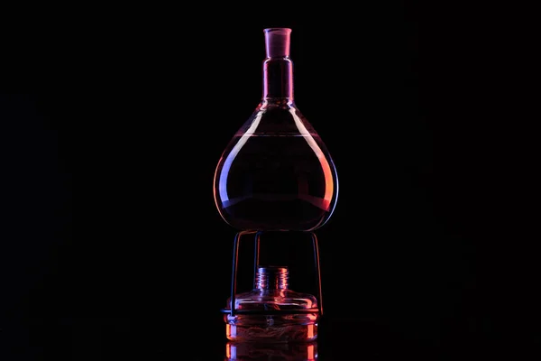 Flacon en verre avec substance chimique sur chauffe-eau noir — Photo de stock