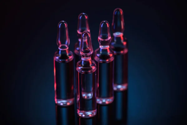 Cinco ampollas de vidrio transparente con sustancia sobre la mesa - foto de stock