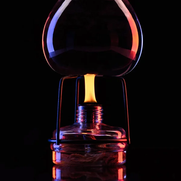 Heating glass jar with liquid in laboratory on black — Stock Photo