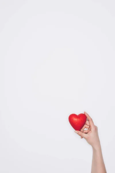 Tiro recortado de la mujer sosteniendo pequeño corazón rojo aislado en blanco - foto de stock