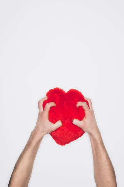 Tiro cortado de homem espremendo travesseiro coração vermelho isolado no branco — Fotografia de Stock