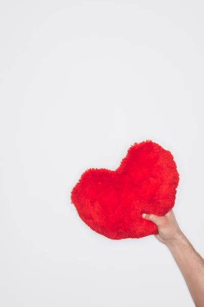 Обрізаний знімок людини, що тримає червону серцеву подушку ізольовано на білому, концепція дня святого Валентина — стокове фото