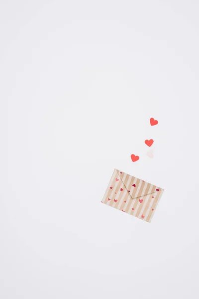 Vista superior del sobre de día de San Valentín decorado con diminutos corazones aislados en el concepto de día de San Valentín blanco — Stock Photo