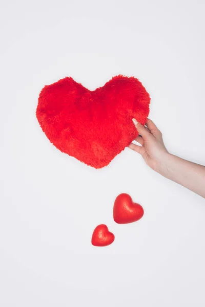 Tiro recortado de mujer sosteniendo almohada suave corazón rojo aislado en blanco - foto de stock